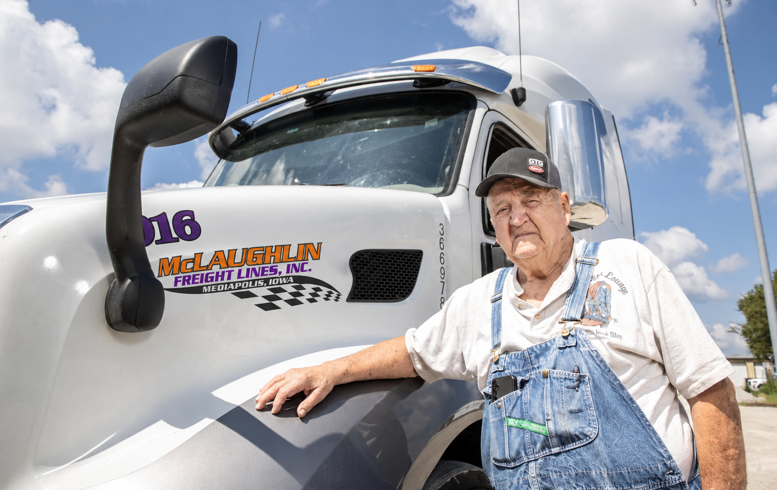 Orrin Asmus, 94-year-old McLaughlin Freight driver, standing next to his truck